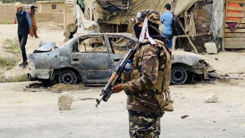 Taliban stands guard near a vehicle which was used to fire rockets at the Hamid Karzai International Airport in Kabul, Afghanistan, 30 August 2021.