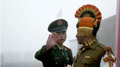 In this photograph taken on July 10, 2008, A Chinese soldier gestures as he stands near an Indian soldier on the Chinese side of the ancient Nathu La border crossing between India and China