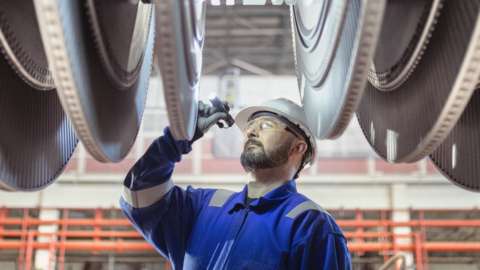 An engineer inspects a turbine in a nuclear power station