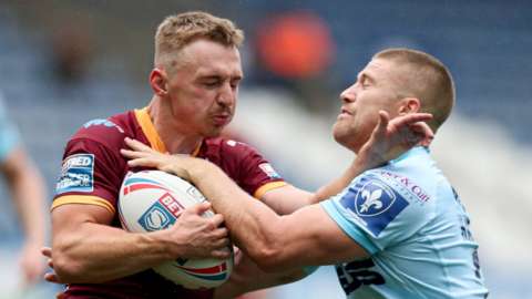 Huddersfield's Olly Ashall-Bott is tackled by Ryan Hampshire of Wakefield