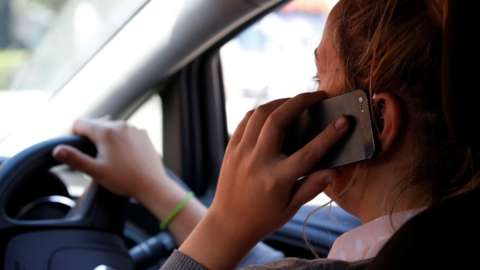 Woman using a mobile phone in the car