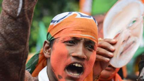 An Indian supporter of Bharatiya Janata Party (BJP) celebrates the party's win in the general election.