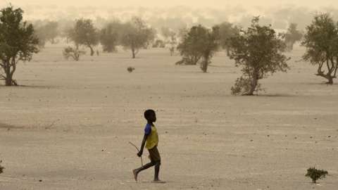 A young boy walks on June 4, 2015, on the dry lake of Faguibine near Bintagoungou in the region of Timbuktu, northern Mali