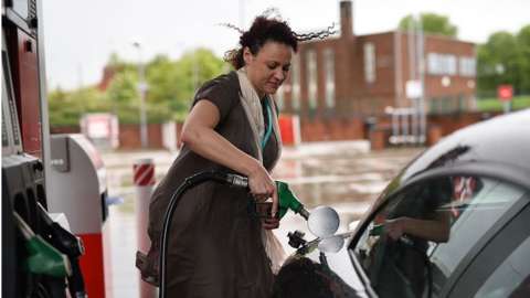 Woman fills car with fuel