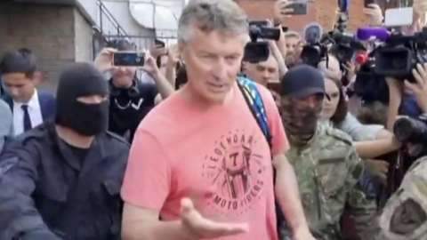 Yevgeny Roizman being led away by authorities.