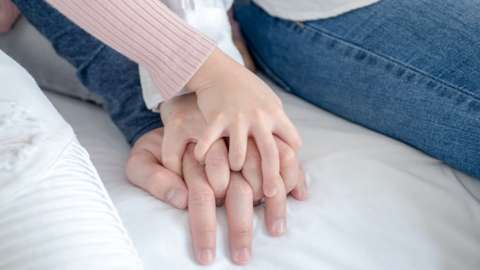 Hands of adults and child