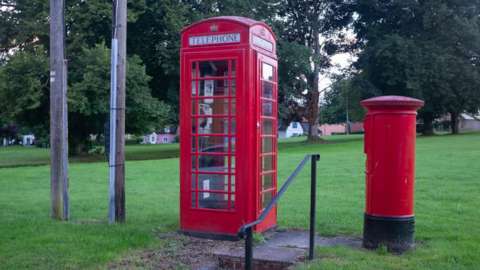 A phone box in a park.