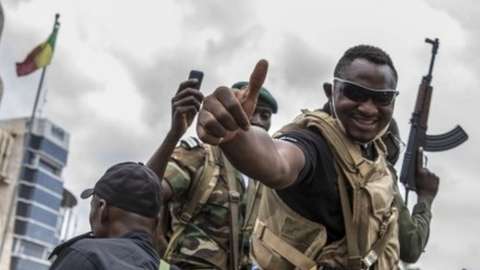 A Malian soldier gives the thumbs up as civilians cheer military and police as they drive through the streets of Bamako, a day after the military seized the Presidency in Bamako, Mali, 19 August 2020.