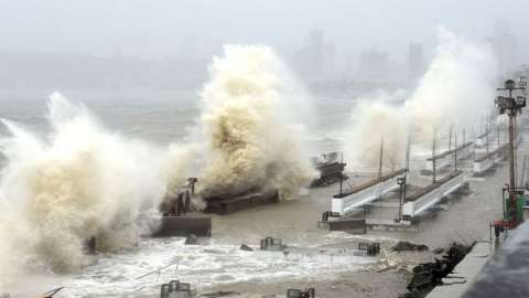 Waves lash over onto a shoreline in Mumbai on May 17, 2021, as Cyclone Tauktae, packing ferocious winds and threatening a destructive storm, surge bore down on India