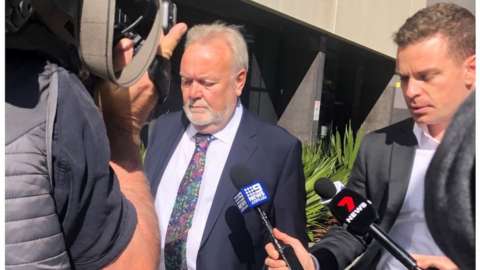 Former NHS boss Malcolm Stamp being surrounded by media as he arrived at Brisbane magistrates court