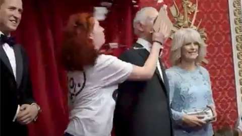 Screen grab taken from a handout video issued by Just Stop Oil of two activists throwing chocolate cake on a waxwork model of King Charles III at Madam Tussauds in London