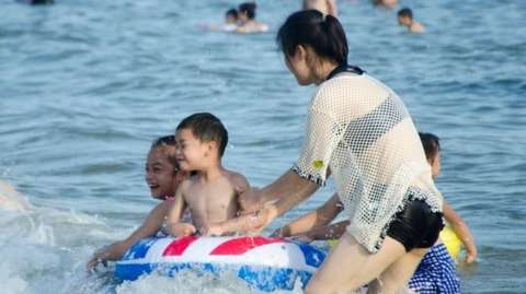 People play in the sea at the Silver Beach tourist resort in Beihai.