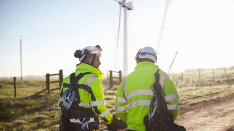 Two engineers at wind farm, walking together