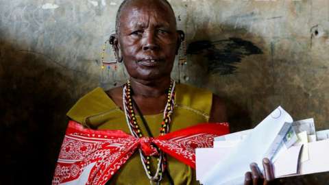 A Maasai traditional woman waits near a voting booth at a polling centre before casting her ballot during the general election by the Independent Electoral and Boundaries Commission (IEBC) in Ewaso Kedong primary school, in Kajiado county, Kenya August 9, 2022