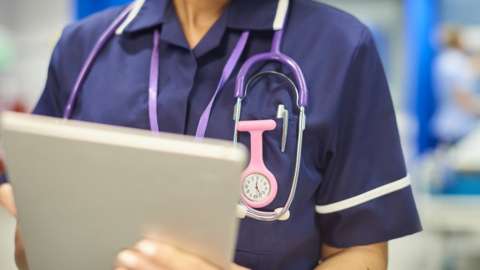 A nurse holding a tablet