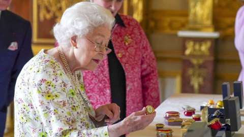 The Queen looks at chinaware