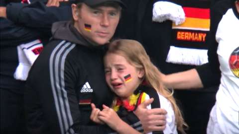 A young Germany fan crying while being hugged