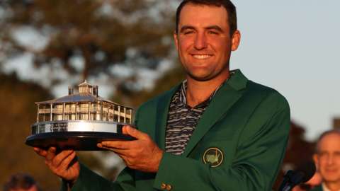 Scottie Scheffler lifts the trophy and wears the Green Jacket after winning the 2022 Masters
