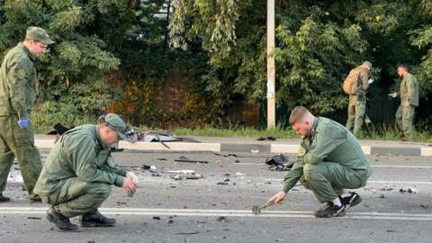 Investigators work at the site of a suspected car bomb attack that killed Darya Dugina
