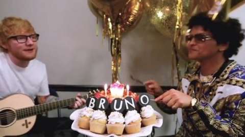 Ed Sheeran with a guitar, while Bruno Mars tucks into birthday cupcakes which spell out the word 'bruno'.