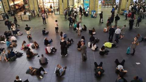 People waiting inside Kingâ€™s Cross station, London, as all services in and out of the station have been suspended, after a large power cut has caused