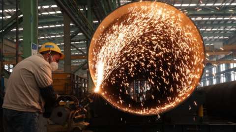 An employee welds steel structure components in Meishan, Sichuan Province of China.