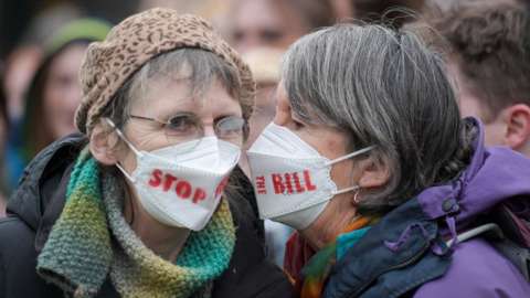 Two people wearing "stop the bill" facemasks