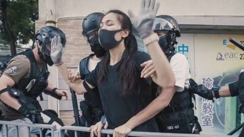 A young protester is detained by the police, after they caught up with her