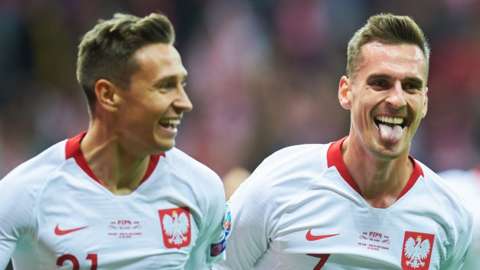 Poland's forward Arkadiusz Milik (R) celebrates scoring the opening goal with Poland's midfielder Przemyslaw Frankowski