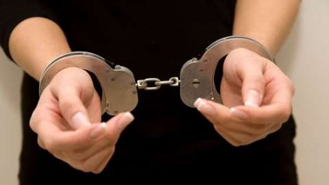 Picture of woman's hands in handcuffs.