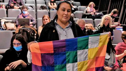 A woman holds an indigenous Wiphala flag during the trial in Buenos Aires, Argentina on 10 May