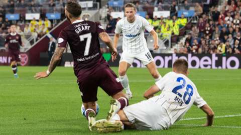 orge Grant is shown a second yellow for simulation under a tackle from Karol Mets during a UEFA Europa League play-off second leg match between Heart of Midlothian and FC Zurich at Tynecastle,