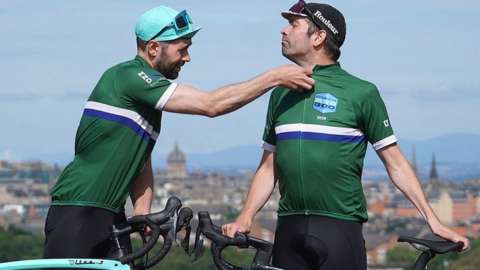 Davy's twin brother Tommy Zyw helping him zip up his cycling shirt