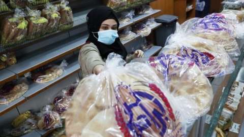 A vendor arranges bread for sale in a bakery in Beirut, Lebanon. Photo: 7 December 2020