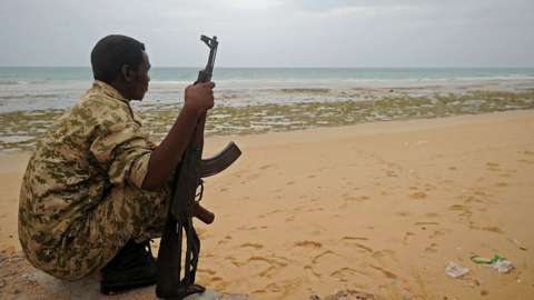 A member of the Somali security forces stands guard on the beach on the coast of Qaw, in Puntland, in 2016.