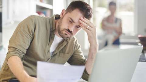 Man worries about finances looking at bills