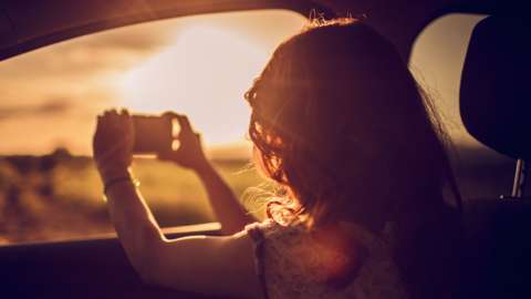 Woman photographing a sunrise