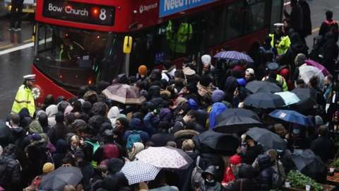 Commuters crowding around a bus