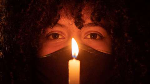 A person holds a candle during a protest in Brasilia
