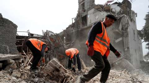 Emergency management specialists and volunteers remove the debris of a theatre building destroyed in the course of Ukraine-Russia conflict in the southern port city of Mariupol,