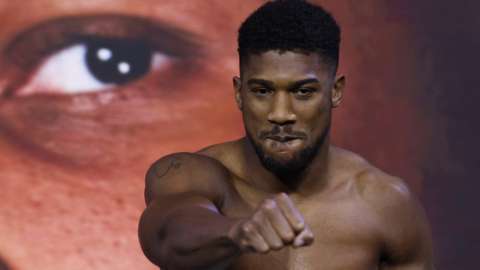 Anthony Joshua holds out his fist at a weigh-in