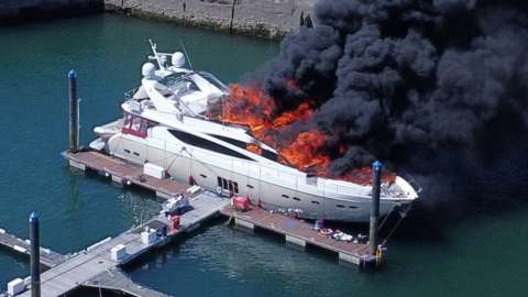 Superyacht with flames and black smoke