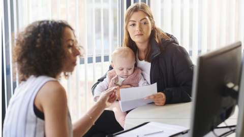 Mother with baby in interview - stock shot