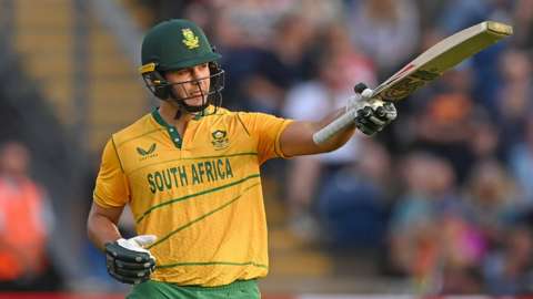 South Africa's Rilee Rossouw holds his bat up after hitting a fifty