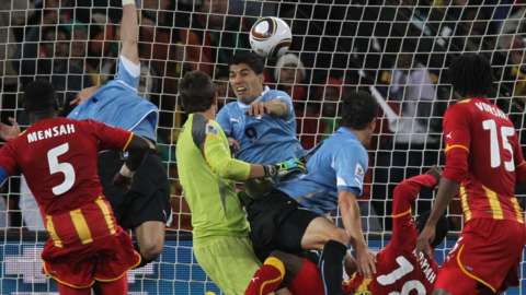 Luis Suarez keeps out a header from Dominic Adiyiah during the Uruguay vs Ghana World Cup quarter-final tie at Soccer City in Johannesburg