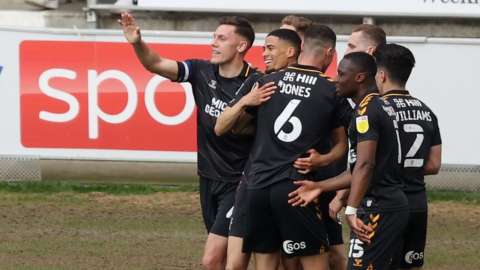 Cambridge United players celebrated their first win at the DW Stadium