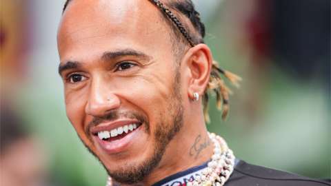 Lewis Hamilton wearing earrings and a chain around his neck