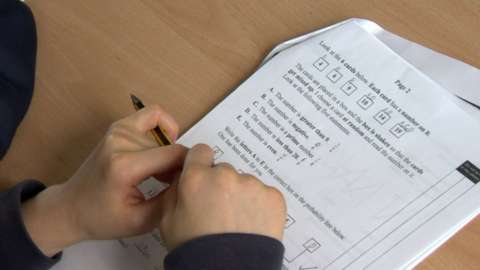 A child writing on an exam paper