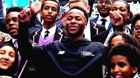 Raheem Sterling cheering with pupils from Ark Elvin Academy.