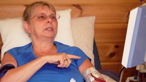 A woman with renal failure points to her haemodialysis machine